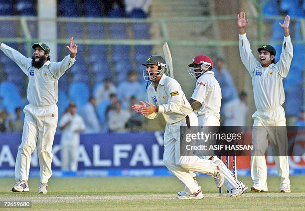 Pakistani cricketers Mohammad Yousuf , Imran Farhat and Mohammad Hafeez make a successful appeal for a catch against West Indies cricketer Dwayne...