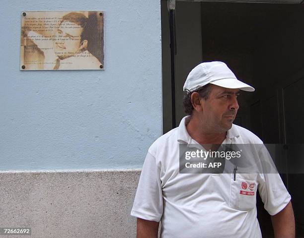 Cuban stays near a plaque with an early picture of President Fidel Castro at a street of Havana 28 November, 2006. Cuba has pulled off what the...