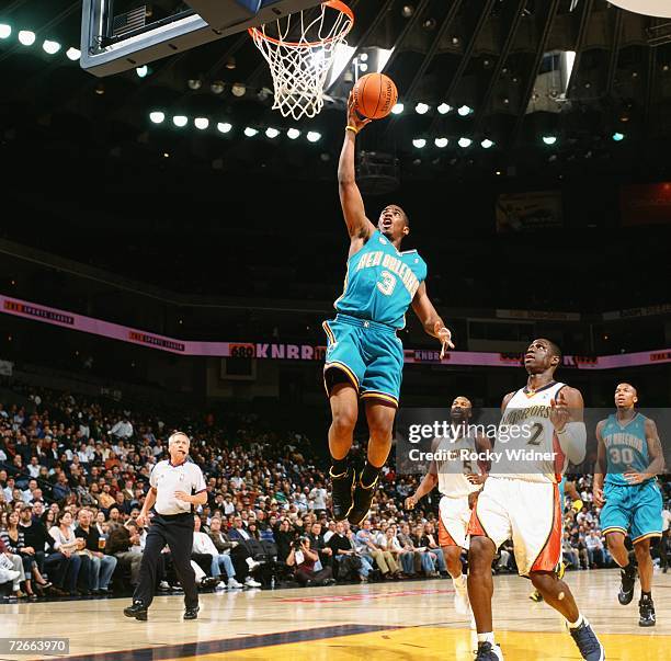 Chris Paul of the New Orleans/Oklahoma City Hornets drives to the basket for a layup past Mickael Pietrus of the Golden State Warriors during a game...