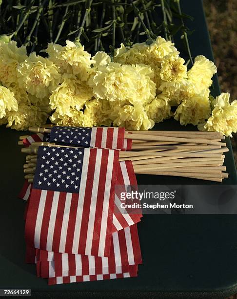 Yellow carnations and small U.S. Flags await soldiers of the U.S. Army, 3rd Infantry Division, 549th Military Police Company to place them at the...