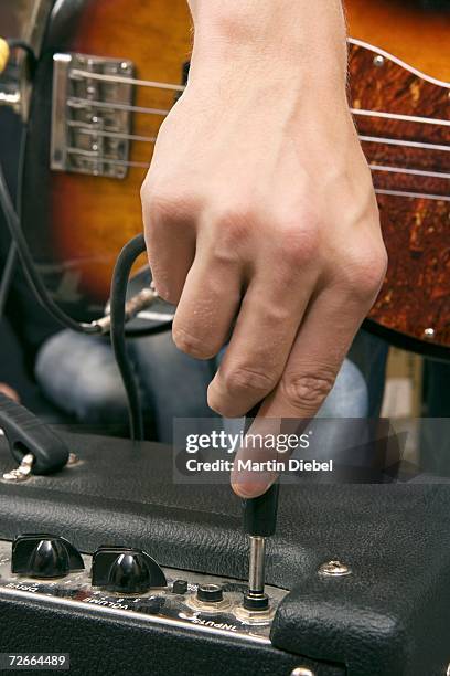 guitarist plugging in amplifier - amplificateur photos et images de collection