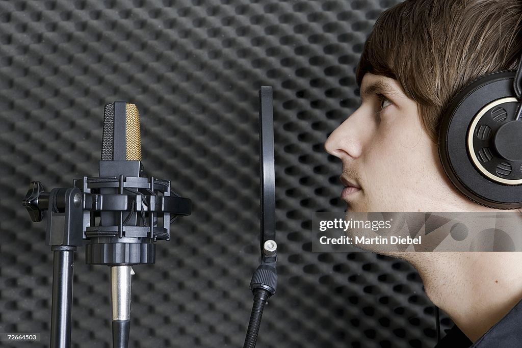 Man in sound booth of recording studio