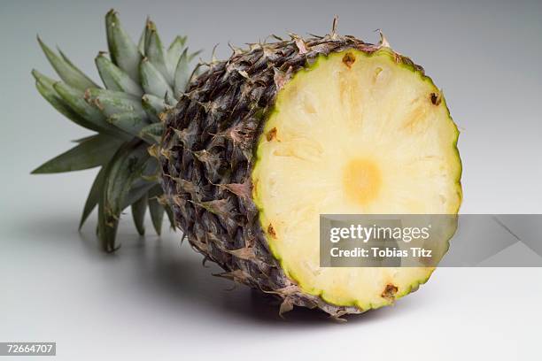 pineapple cut in half - ananas aufgeschnitten stock-fotos und bilder