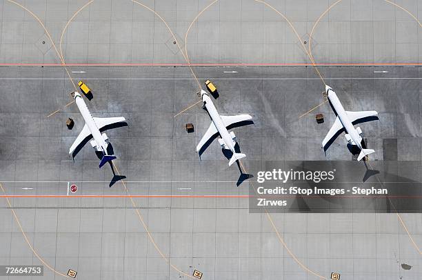 aerial view of three airplanes in a row - aeroporto pista foto e immagini stock