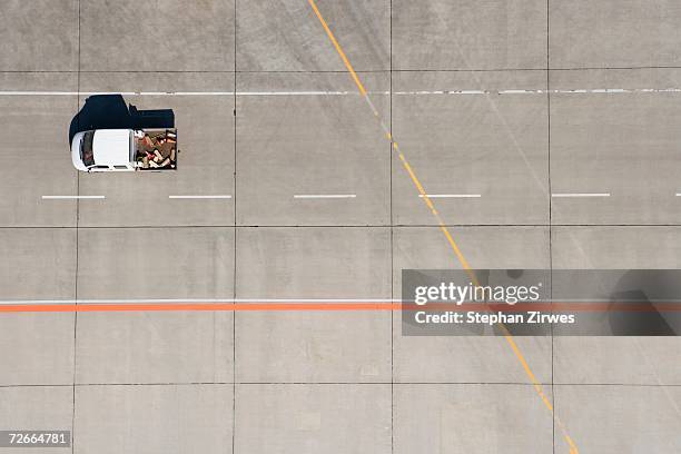 aerial view of van driving across airport tarmac - runway stock-fotos und bilder