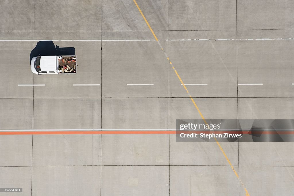 Aerial view of van driving across airport tarmac