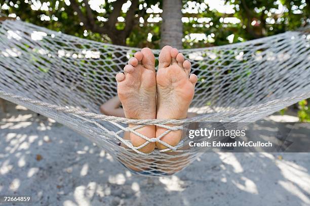 close up of person?s feet lying in hammock - female soles stockfoto's en -beelden