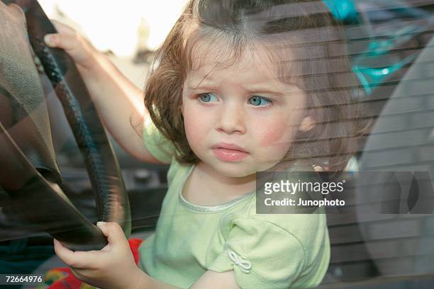 young girl sitting in driver?s seat of car - driver's seat ストックフォトと画像