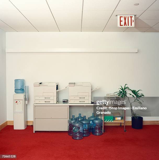 photocopy machines next to water cooler in office - water cooler stockfoto's en -beelden