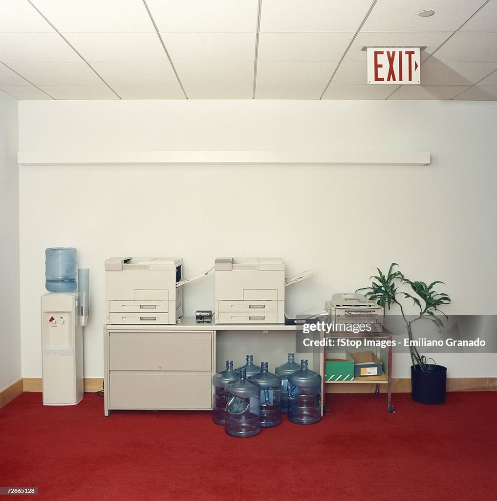 Photocopy machines next to water cooler in office