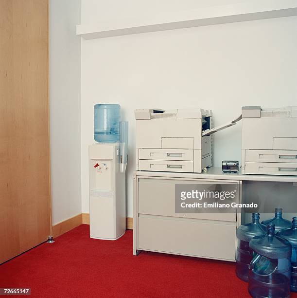 photocopy machines next to water cooler in office - trinkwasserbehälter stock-fotos und bilder