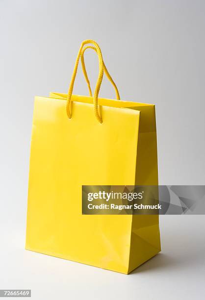 yellow gift bag - papier tüte stock-fotos und bilder