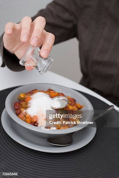 man holding empty salt shaker above ruined meal - salt shaker stockfoto's en -beelden