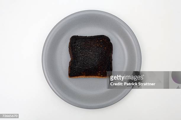 slice of burnt toast on plate - burnt bread stock pictures, royalty-free photos & images