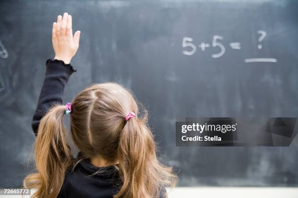 girl in classroom with raised hand - children raising their hands stock pictures, royalty-free photos & images