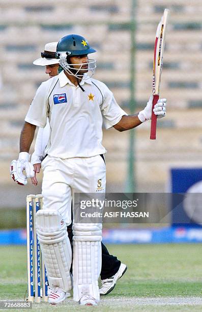 Pakistani cricketer Mohammad Hafeez waves his bat after scoring a half century against West Indies during the third day of the third and final Test...