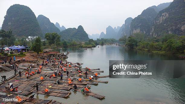 Villagers wait for tourists on bamboo rafts on the Lijiang River on November 18, 2006 in Yangshuo County of Guilin, Guangxi Zhuang Autonomous Region,...