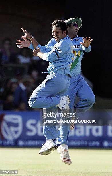 Port Elizabeth, SOUTH AFRICA: Indian bowler Sachin Tendulkar celebrates with Indian captain Virender Sehwag 29 November 2006 after sending out South...