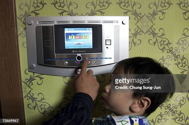 Ji Young-Hoon , and his son Ji Tae-Hee control electronic appliances in his house with a main control panel at the smart home town complex on...