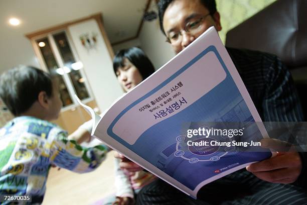 Ji Young-Hoon , and his family read operation manual of their home network system on November 29, 2006 in Incheon, South Korea. The Home Network uses...