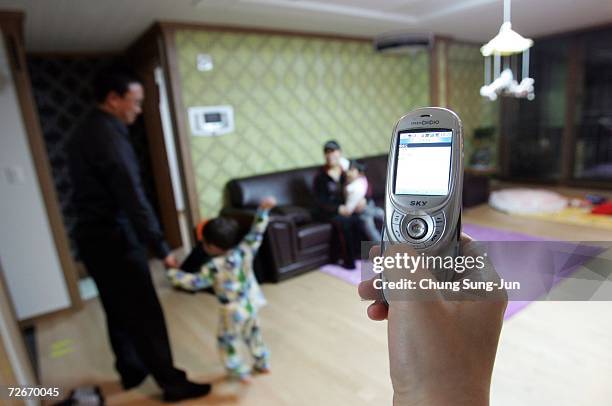 Moon Sook-Kyung , controls an electronic appliance of her house with her mobile phone on November 29, 2006 in Incheon, South Korea. The Home Network...