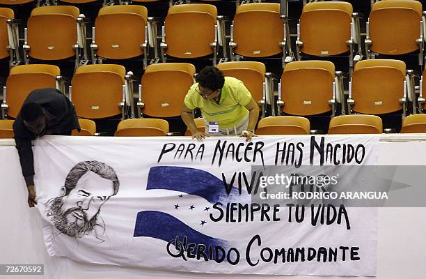 Dos personas cuelgan una manta para el presidente cubano Fidel Castro, en el Palacio de las Convenciones de la Habana, el 29 de noviembre de 2006. La...