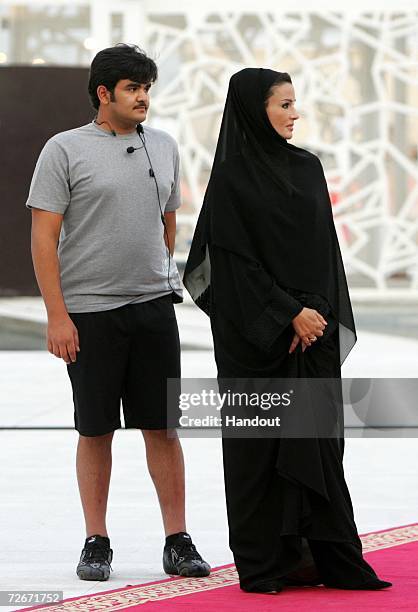 Her Highness Sheikha Mozah Bint Nasser Abdullah Al Missned, Consort of the Emir of Qatar stands with her son Sheikh Hamad Bin Khalifa Al-Thani, the...