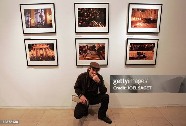 Le photographe de l'Agence France Presse Olivier Laban-Mattei pose devant des cliches de son reportage consacre a la "Prise de la Sorbonne" lors de...