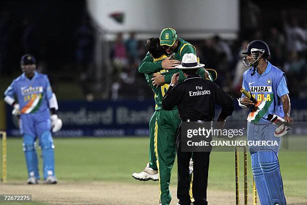 Port Elizabeth, SOUTH AFRICA: South African bowler Justin Kemp and South African captain celebrate, 29 November 2006, as Kemp sent out Indian batsman...