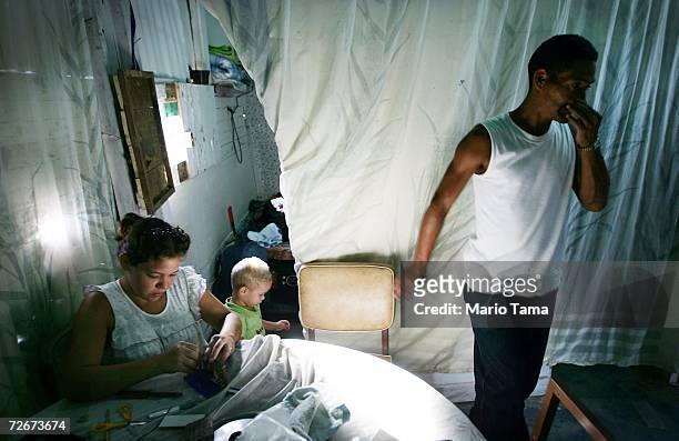 Residents gather in the poor barrio of Coche beneath a portrait of Jesus November 29, 2006 in Caracas, Venezuela. Despite daily problems with fresh...