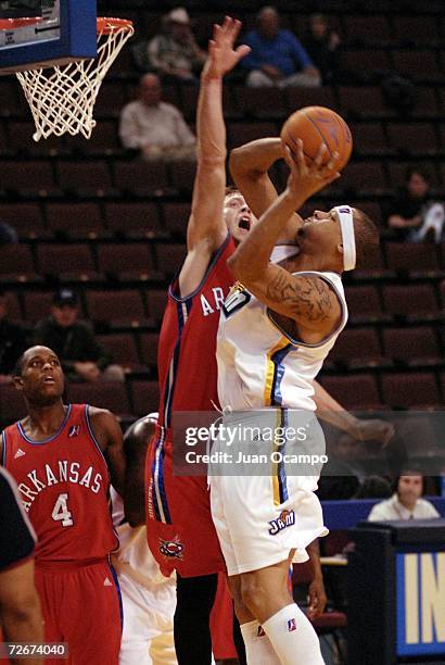Roderick Riley of the Bakersfield Jam has his shot challenged by Brian Jackson of the Arkansas RimRockers as Jason Smith looks on on November 29,...