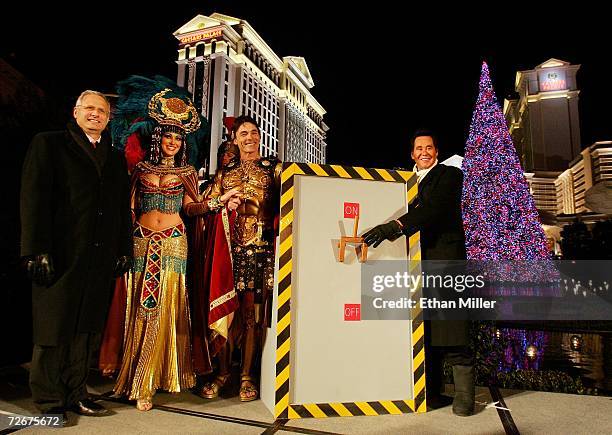 Caesars Palace President Gary Selesner and entertainer Wayne Newton pose with Caesar and Cleopatra characters after flipping a ceremonial switch to...
