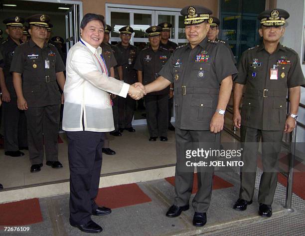 Outgoing Philippine Defense Secretary Avelino Cruz shakes hands with Army General Lieutenant General Romeo Tolentino and other military officials as...