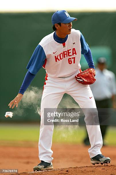 Pitcher Kyu Min Woo of the Republic of Korea throws the chalk bag before his pitch during the Round Robin game against Chinese Taipei at the 15th...