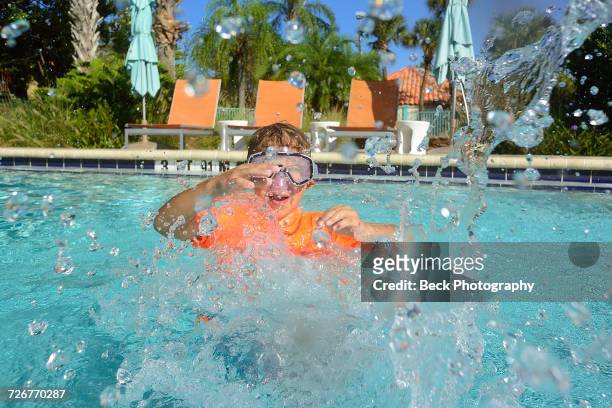 boy swims in a pool - orlando florida stock pictures, royalty-free photos & images