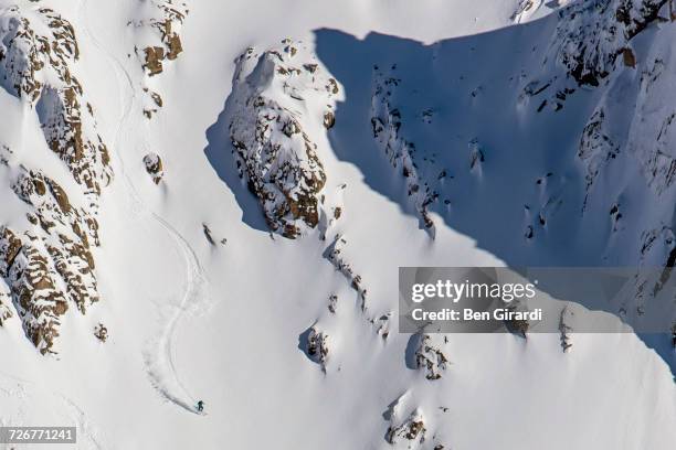 a man skiing at a big mountain line and gets fresh tracks after ski touring at a backcountry area surrounding cerro catedral in argentina - scialpinismo foto e immagini stock
