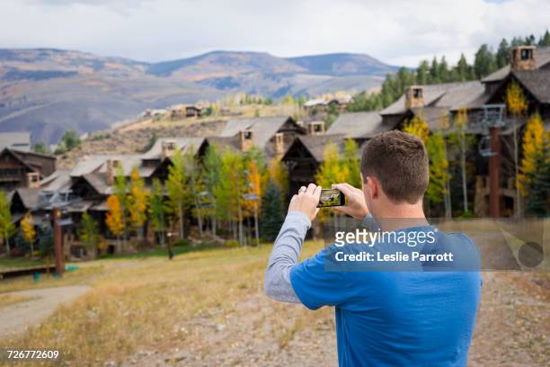man taking a photo of fall scenery with a smartphone - solo un uomo foto e immagini stock