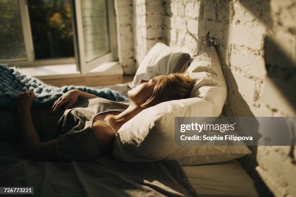 caucasian woman sleeping in bed near open window - sleeping and bed bildbanksfoton och bilder