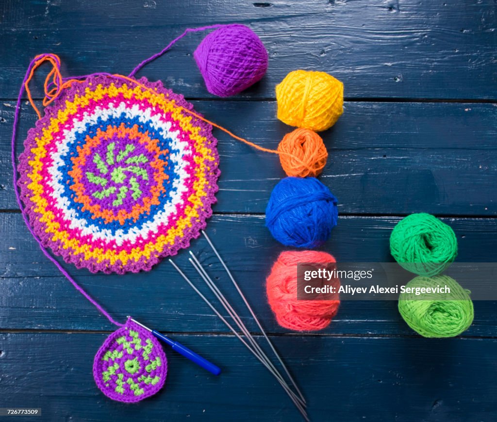 Knitting needles and multicolor yarn on blue table