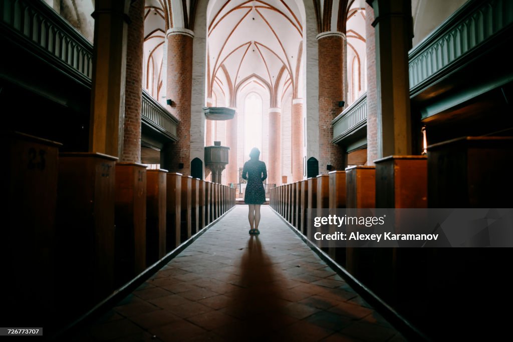Caucasian woman standing in aisle of church