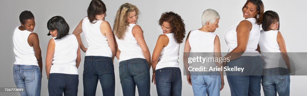 Diverse women looking over shoulders at their buttocks