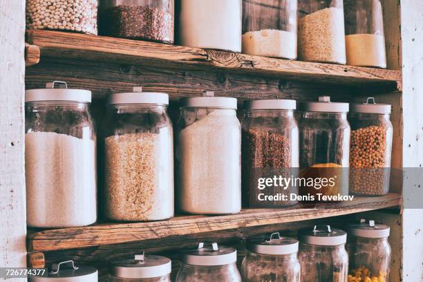 jars of ingredients on wooden shelves - food pantry fotografías e imágenes de stock