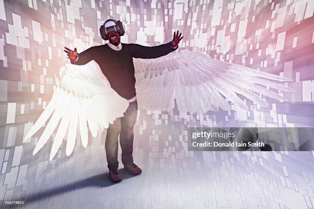 Man with angel wings wearing virtual reality helmet