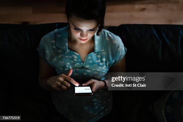 woman texting on cell phone in the dark - blick nach unten stock-fotos und bilder