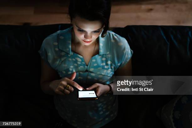 woman texting on cell phone in the dark - look down stock pictures, royalty-free photos & images
