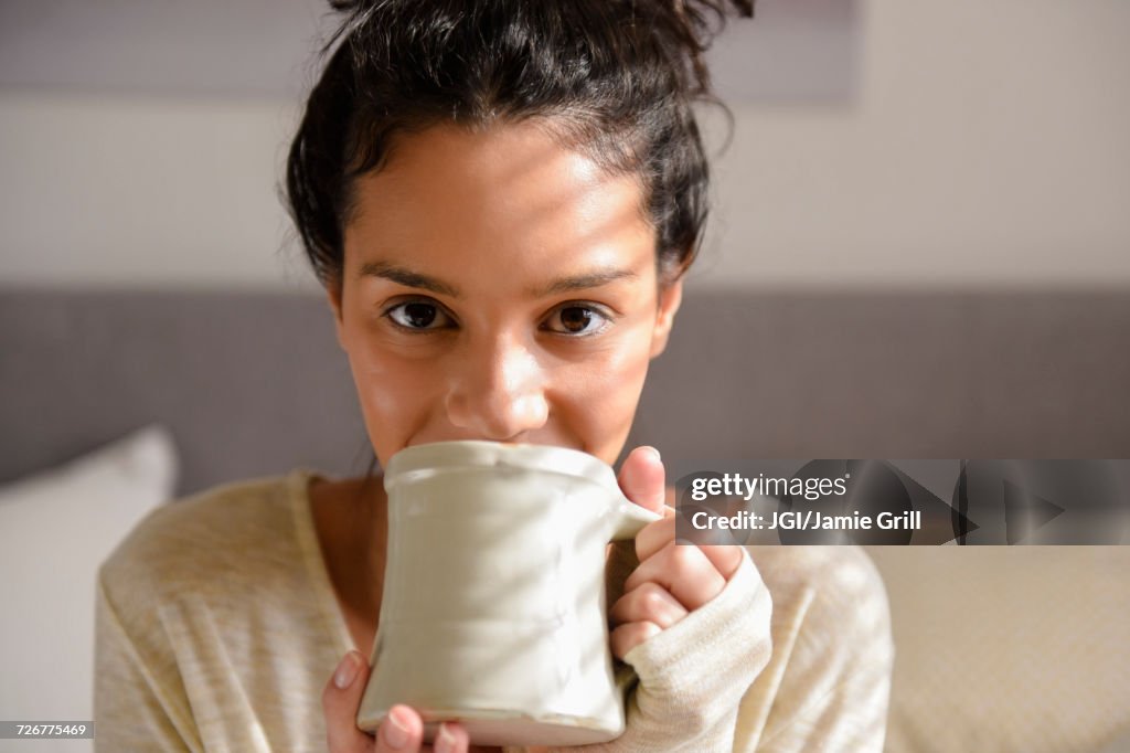 Hispanic woman drinking coffee