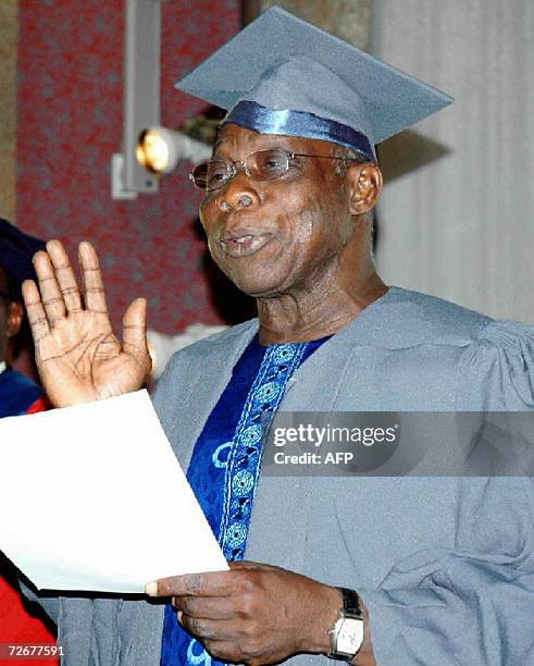 Nigerian Preseident Olusegun Obasanjo takes the oath as a student of the national open university at the presidential villa 29 November 2006, in...