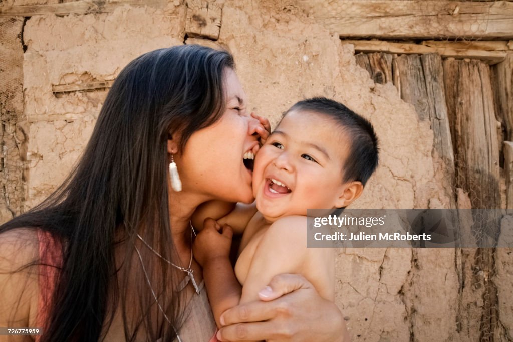 Playful mother holding son outdoors