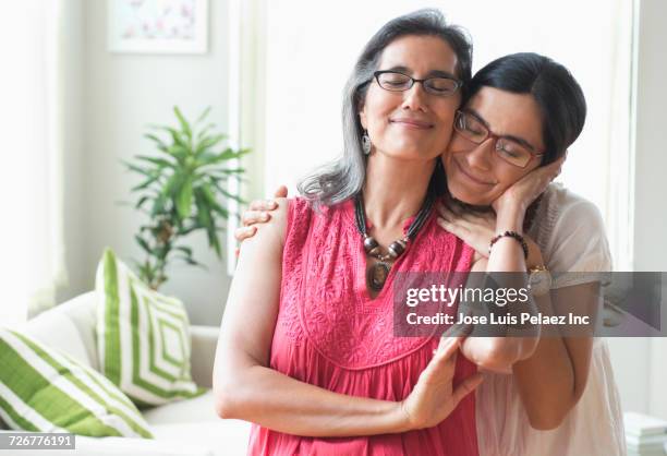 portrait of daughter leaning on shoulder of mother - cheek to cheek stock pictures, royalty-free photos & images