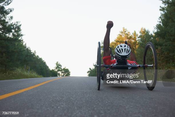 African American man riding handcycle and celebrating